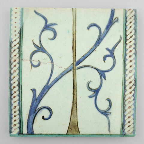 Carreau à décor de tronc d'arbre et rinceau bleu encadré par un motif de tresse