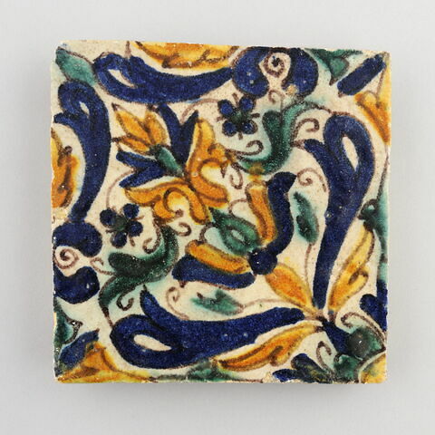 Carreau à décor d'arabesques géométriques et florales bleues, jaunes et vertes