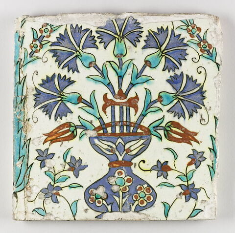 Carreau au vase d'oeillets encadré de cyprès et décoré de fleurettes polychromes, image 1/1