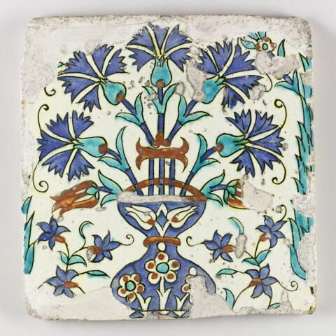 Carreau au vase d'oeillets encadré de cyprès et décoré de fleurettes polychromes, image 1/1
