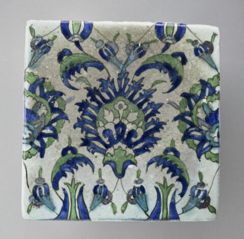Carreau à palmette feuillue au centre d'yun réseau de fleurs épanouies, de tulipes et de petites feuilles dentelées, image 1/2