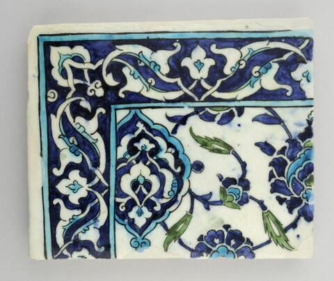 Carreau participant à un panneau à décor de fleurs hatayi épanouies et de mandorles meublées de rumi. Bordure