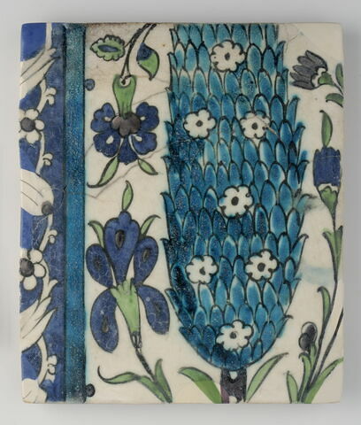 Carreau au cyprès accompagné d'un oeillet et d'un iris. Bordure à rinceau floral sur fond bleu