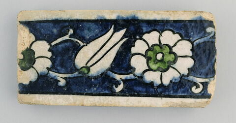 Carreau de bordure au rinceau porteur de rosettes et d'une tulipe sur fond bleu, image 1/2