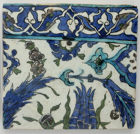 Carreau de bordure (latéral gauche ou droit) d'une composition aux longues feuilles saz et gerbes de fleurs bordée d'une frise de palmettes et de fleurons en réserve sur fond bleu cobalt, image 1/2