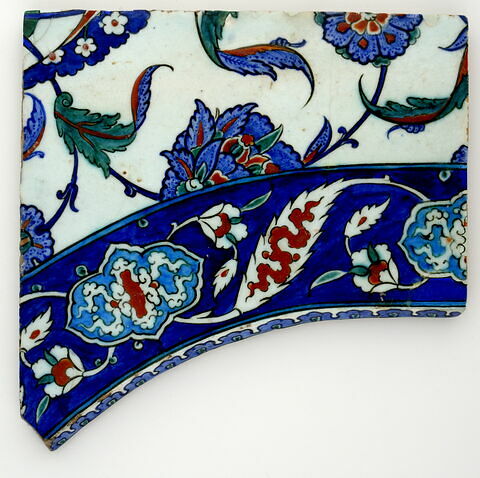Fragment d'écoinçon aux médaillons polylobés et aux feuilles dentelées décorées de nuages sur fond bleu. Champ principal à décor floral saz, image 1/2