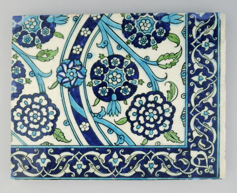 Carreau à décor de tiges ondulantes fleuries de rosettes et bordure à fleurons bifides rumi et fleurons, image 1/1