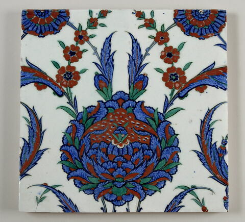 Carreau à décor floral entouré d'une bordure verte à décor de feuilles saz, image 1/2