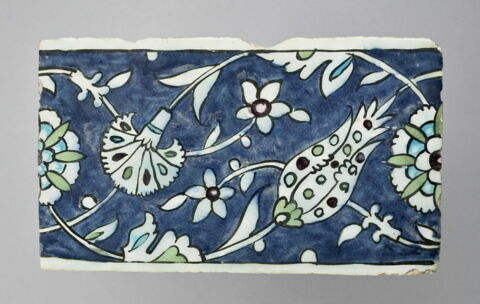 Carreau de bordure à rinceaux entrelacés de tulipes, oeillets et rosettes sur fond bleu, image 1/2