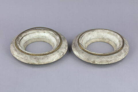 Deux bases rondes en marbre blanc cerclées d'un ruban métallique