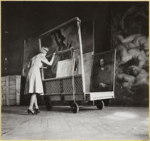 [Le Portrait d'homme, dit autrefois Robert Arnaud d'Andilly, de Philippe de Champaigne et deux autres tableaux sur un chariot devant La Liberté guidant le peuple d'Eugène Delacroix et Le débarquement de la reine à Marseille de Pierre Paul Rubens]