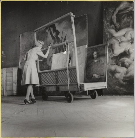 [Le Portrait d'homme, dit autrefois Robert Arnaud d'Andilly, de Philippe de Champaigne et deux autres tableaux sur un chariot devant La Liberté guidant le peuple d'Eugène Delacroix et Le débarquement de la reine à Marseille de Pierre Paul Rubens]