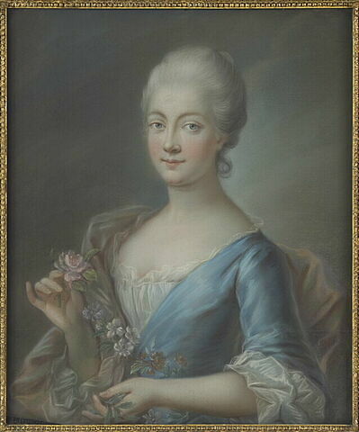 Femme, vue en buste, vêtue d'un corsage bleu et tenant une rose.