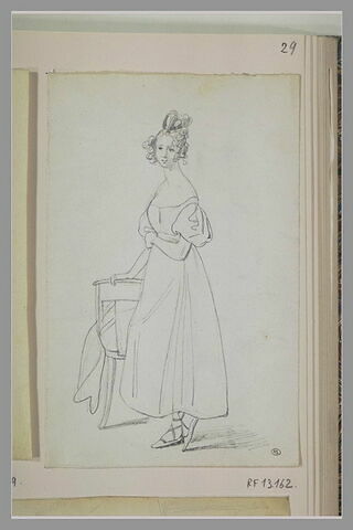 Jeune femme debout, appuyée sur le dossier d'une chaise, image 1/1