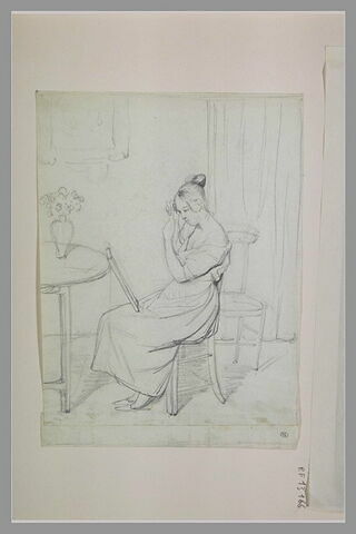 Jeune femme assise sur une chaise, se coiffant devant un miroir, image 1/1