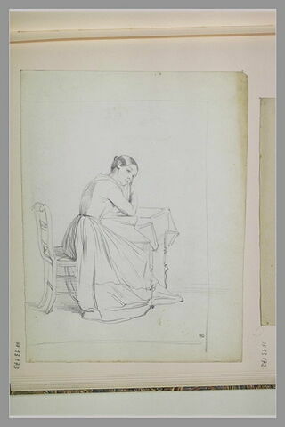 Femme assise, accoudée sur une petite table, image 1/1