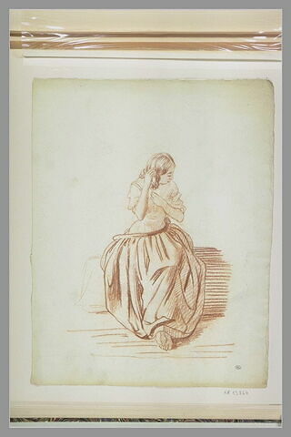 Jeune femme, assise, la main dans les cheveux, image 1/1