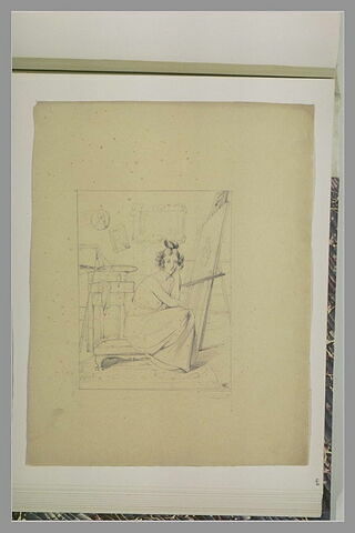 Femme assise, le torse nu, dans un atelier, près d'un chevalet, image 1/1