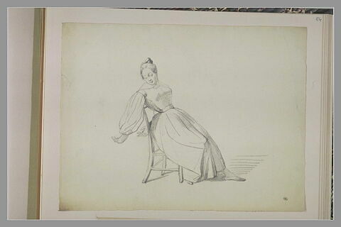 Femme assise sur une chaise, s'étirant, image 1/1