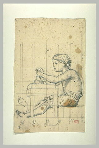Jeune garçon, assis, de profil, devant une table, image 1/1