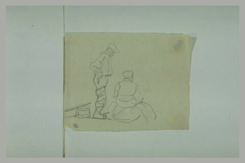 Deux hommes, l'un debout, l'autre assis sur un sac, image 1/1