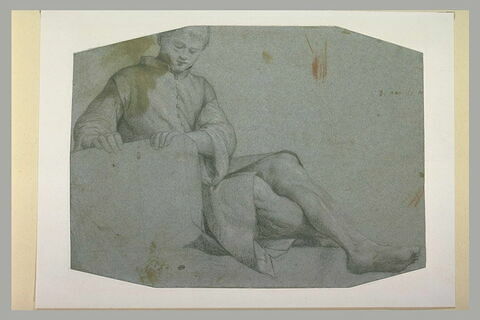 Jeune homme assis, les jambes étendues, les deux mains posées sur une pierre