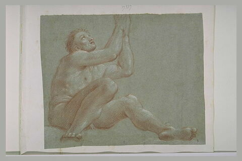Un homme nu, assis à terre, les yeux et les mains levés au ciel, image 1/1