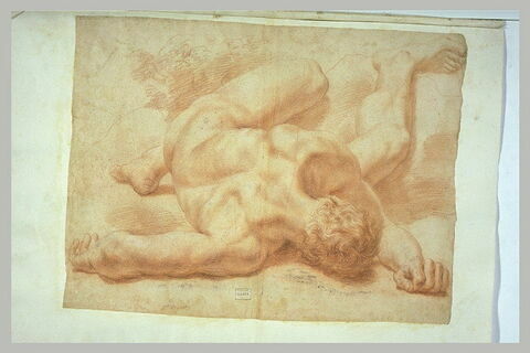 Homme nu, à terre, étendu en arrière, le visage contre le sol, image 1/1