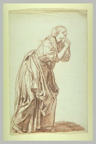 Une femme debout, penchée, les mains jointes, image 2/3