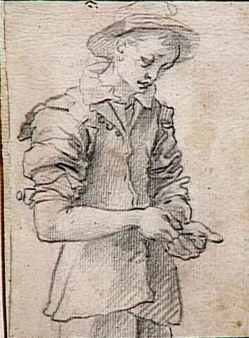 Jeune garçon à mi-corps, regardant un objet qu'il tient dans ses mains, image 1/1