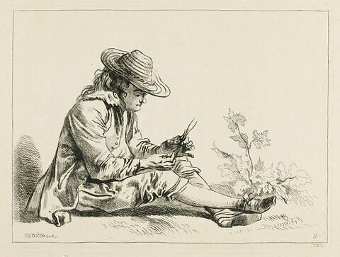 Homme assis à terre tenant des brins d'herbe, image 1/1