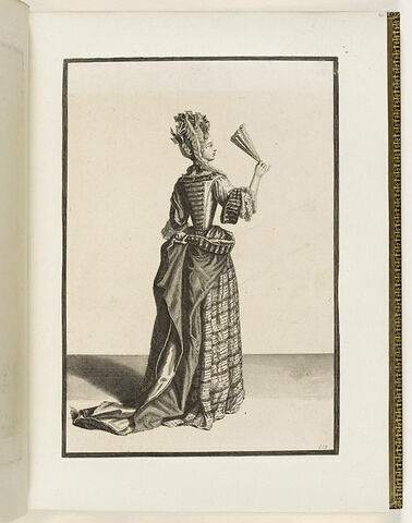 Une femme debout de dos, portant un éventail dans sa main droite, image 1/1