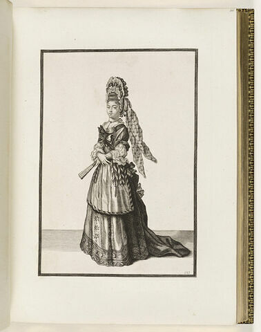 Une femme debout, portant une ample coiffe sur la tête et un éventail dans la main gauche, image 1/1