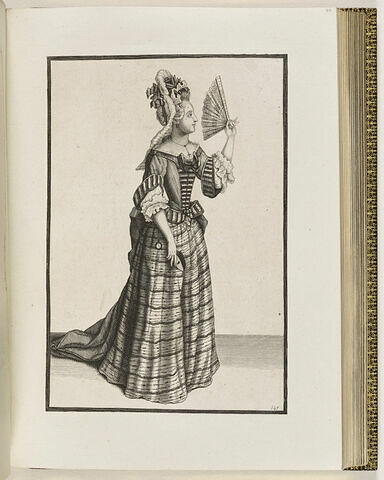 Une femme debout de profil, portant un masque et un éventail dans ses mains, image 1/1