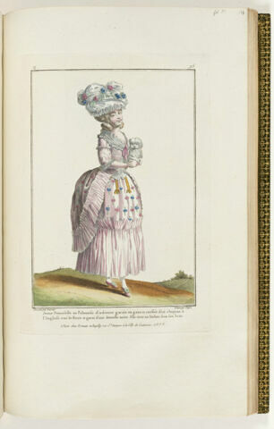 Jeune Demoiselle en Polonoise d'indienne garnie en gaze et coeffée d'un chapeau à l'Anglaise orné de fleurs et garni d'une dentelle noire. Elle tient un bichon sous son bras.