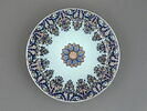 Grand plat circulaire en faïence, décor bleu et rouge de lambrequin au marli, et d'une rosace au centre., image 1/5