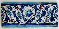 Carreau de bordure à décor de palmettes feuillues et de feuilles dentelées décorées de tulipes sur fond bleu, image 1/2