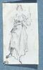 Une femme, debout, tenant un objet dans sa main gauche, image 1/2