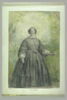 Femme vêtue d'une robe à crinoline grise, devant un bosquet, image 2/2