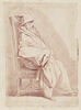 Homme barbu, coiffé d'un bonnet, assis dans un fauteuil, de profil, image 1/2